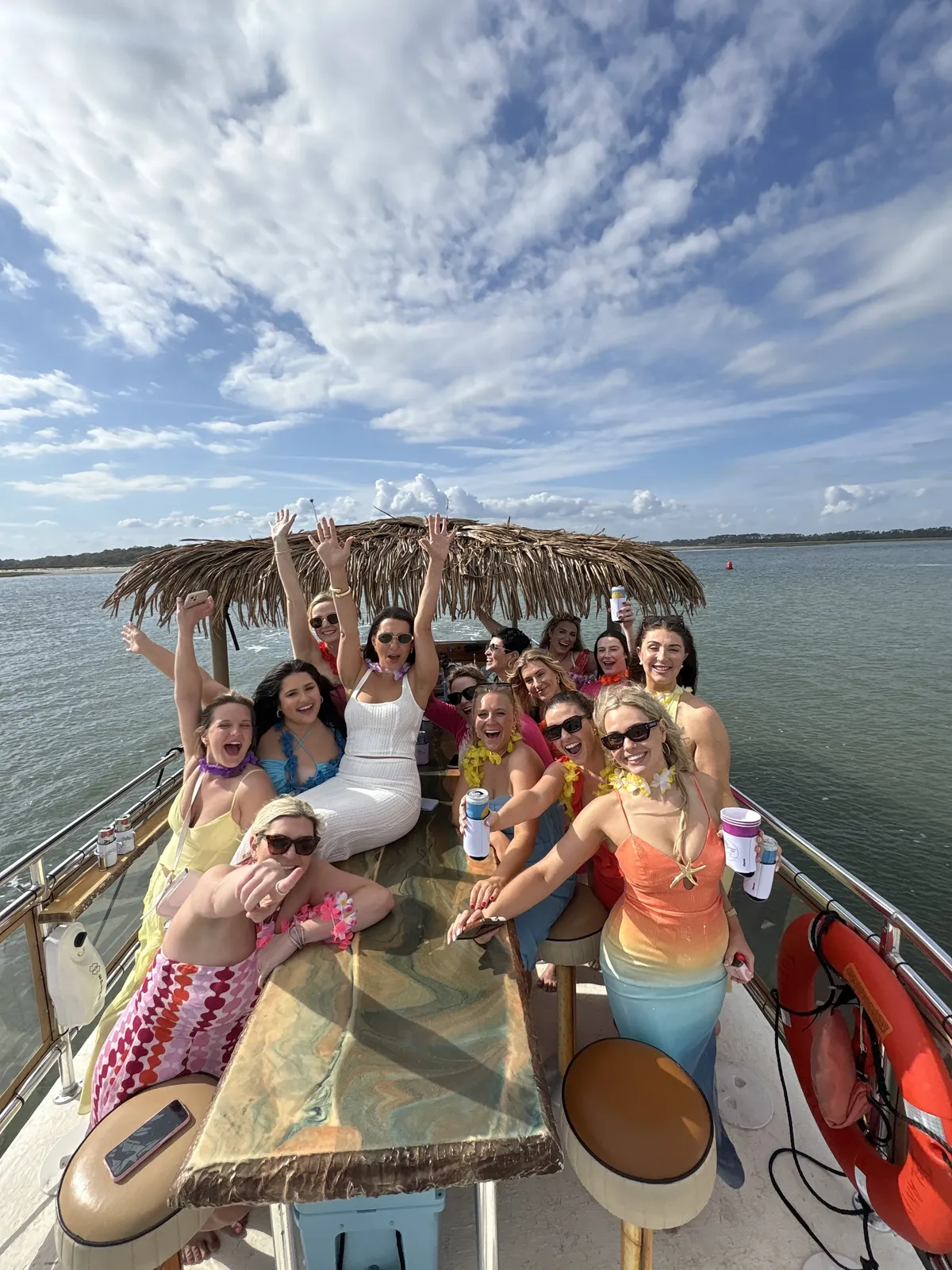 Guests celebrating at the bow under the thatch roof