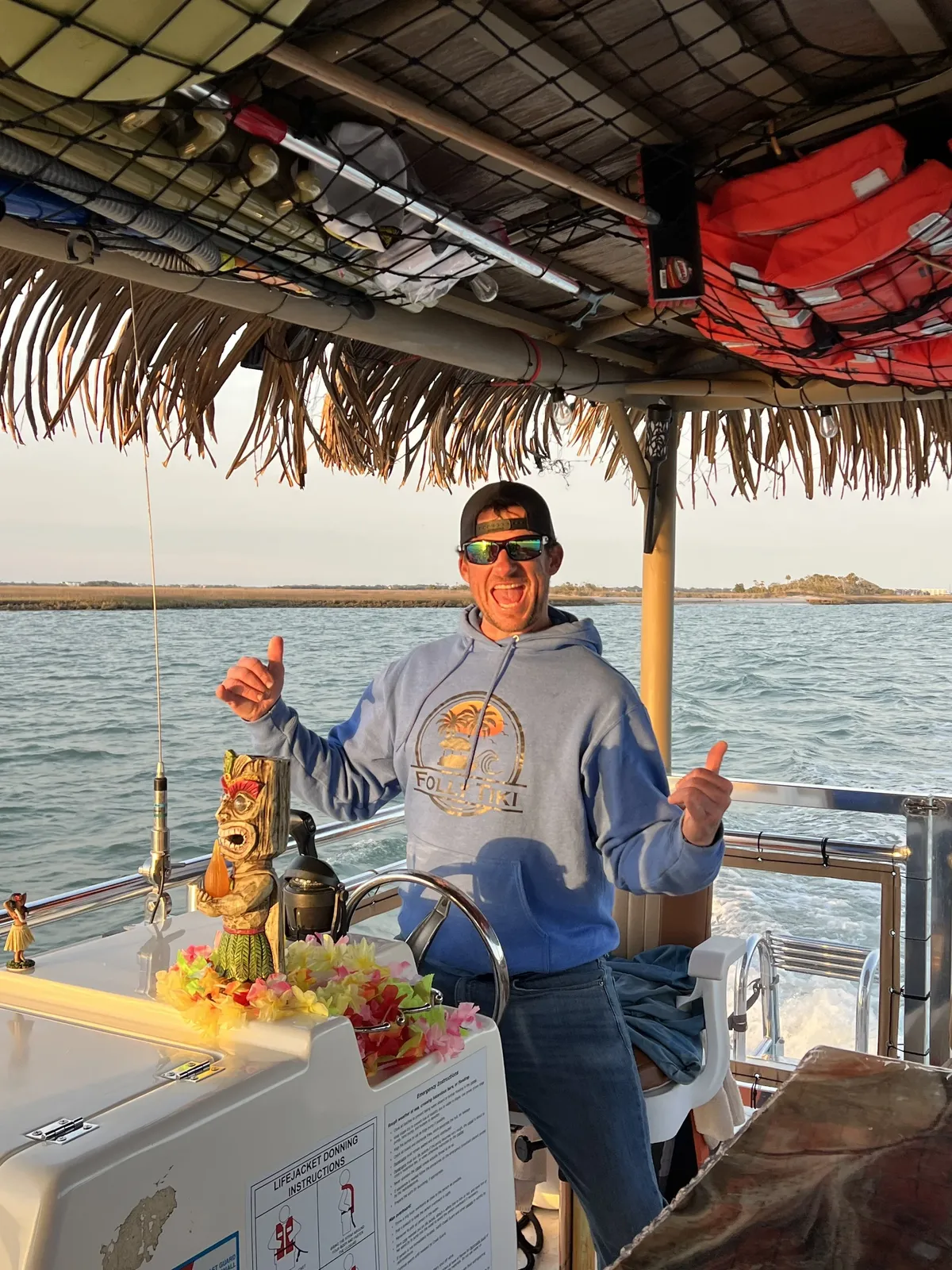 The captain at the helm under the thatch roof