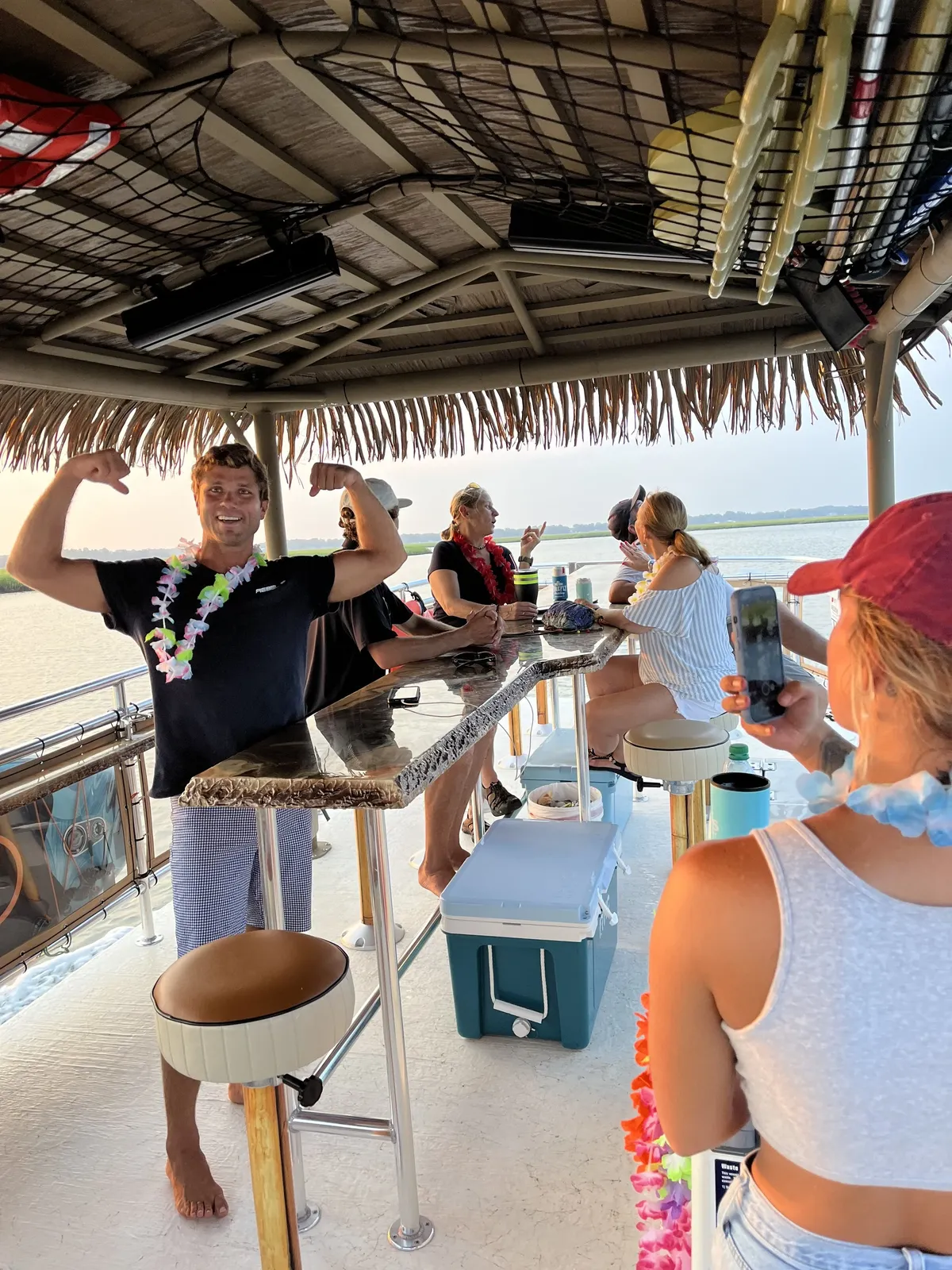 Guests raising drinks around the center tiki bar