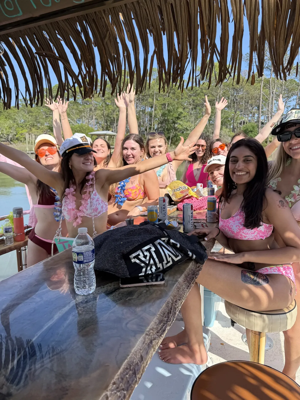Friends toasting drinks under the thatched roof of the tiki boat