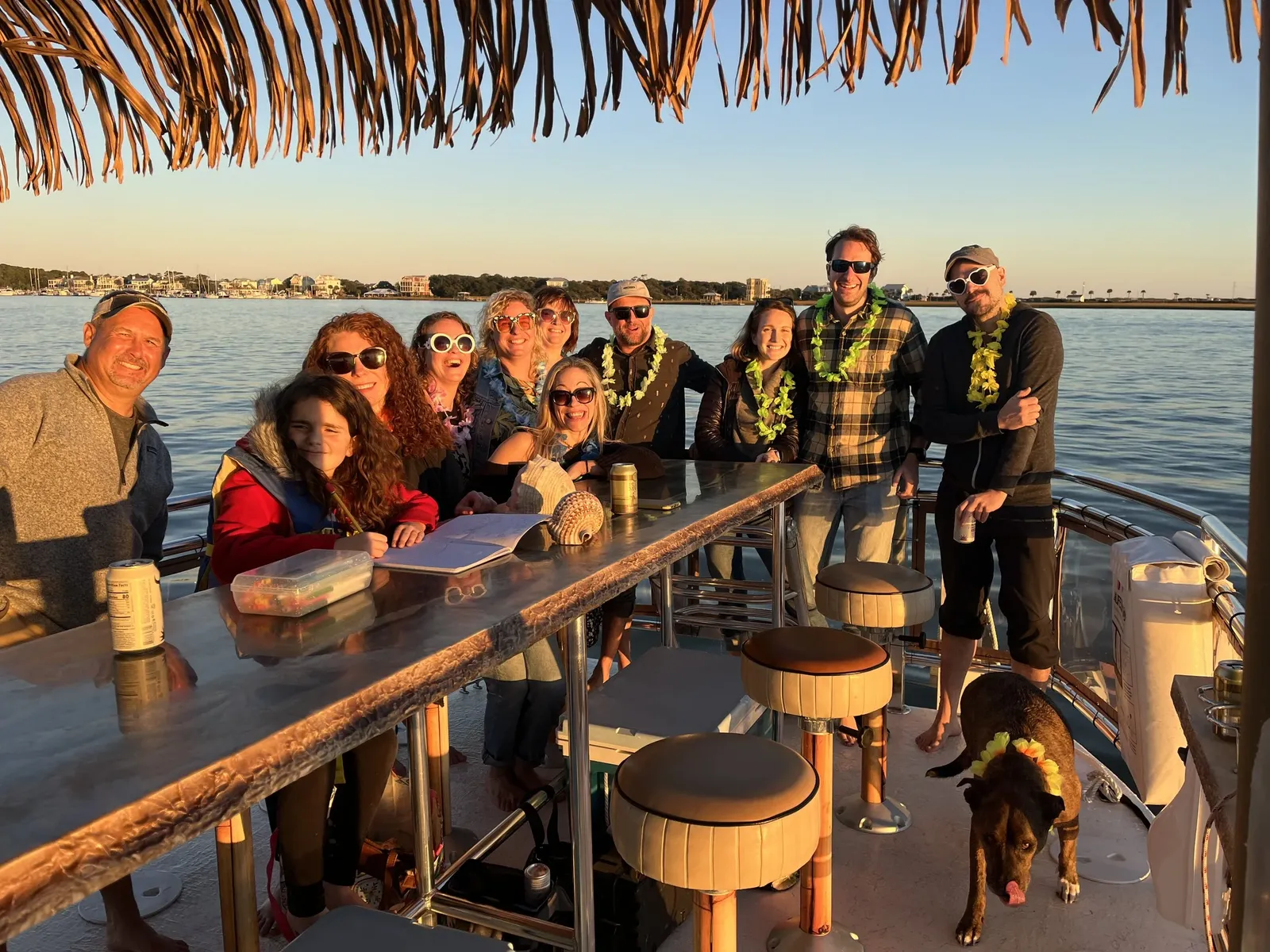 Guests and a dog gathered around the tiki bar at golden hour