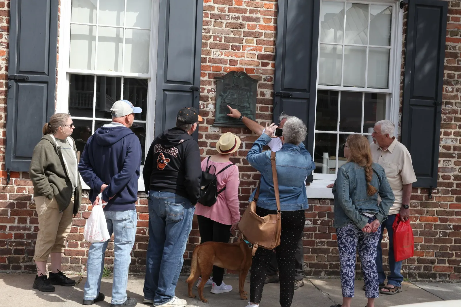 A walking history tour guide leading a small group through downtown Charleston