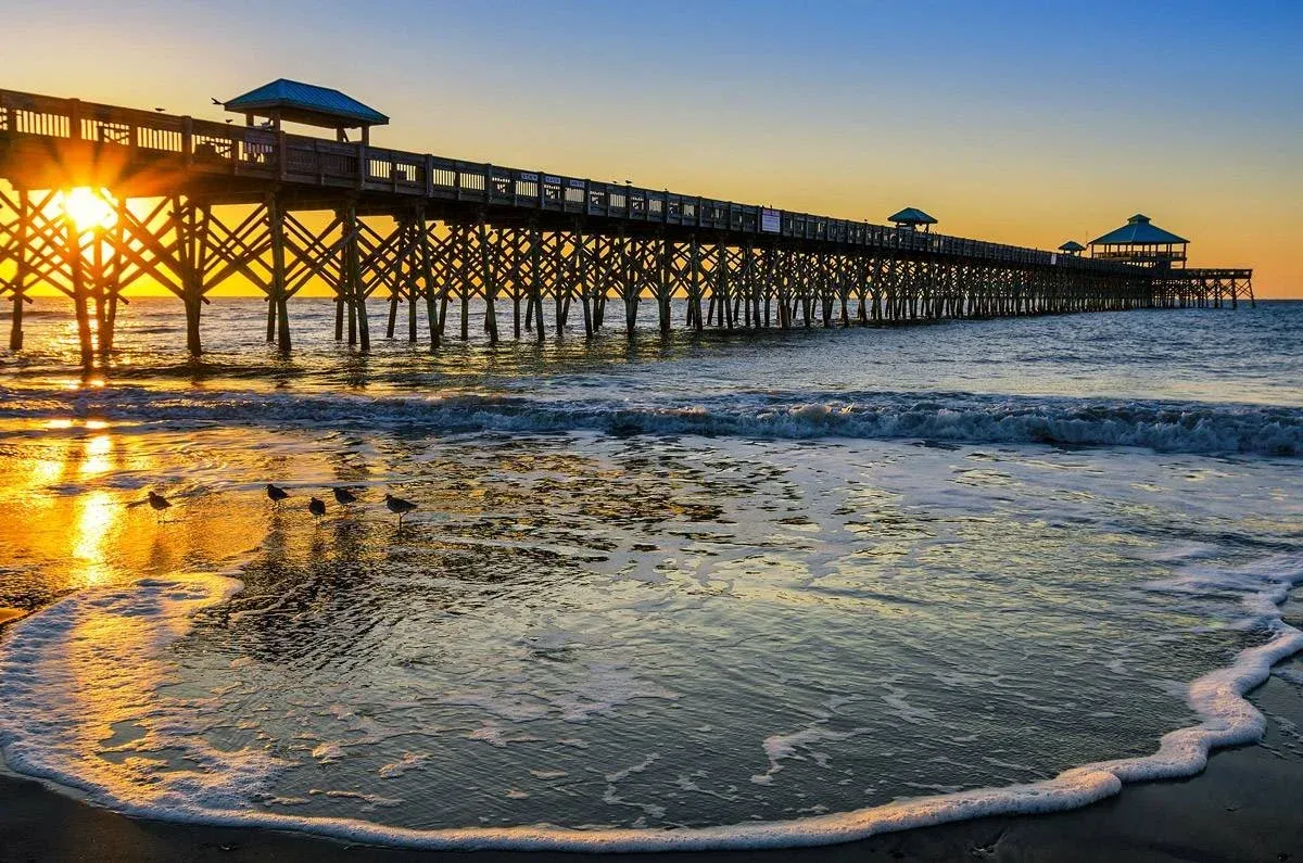 Sunrise breaking over the sand at Folly Beach