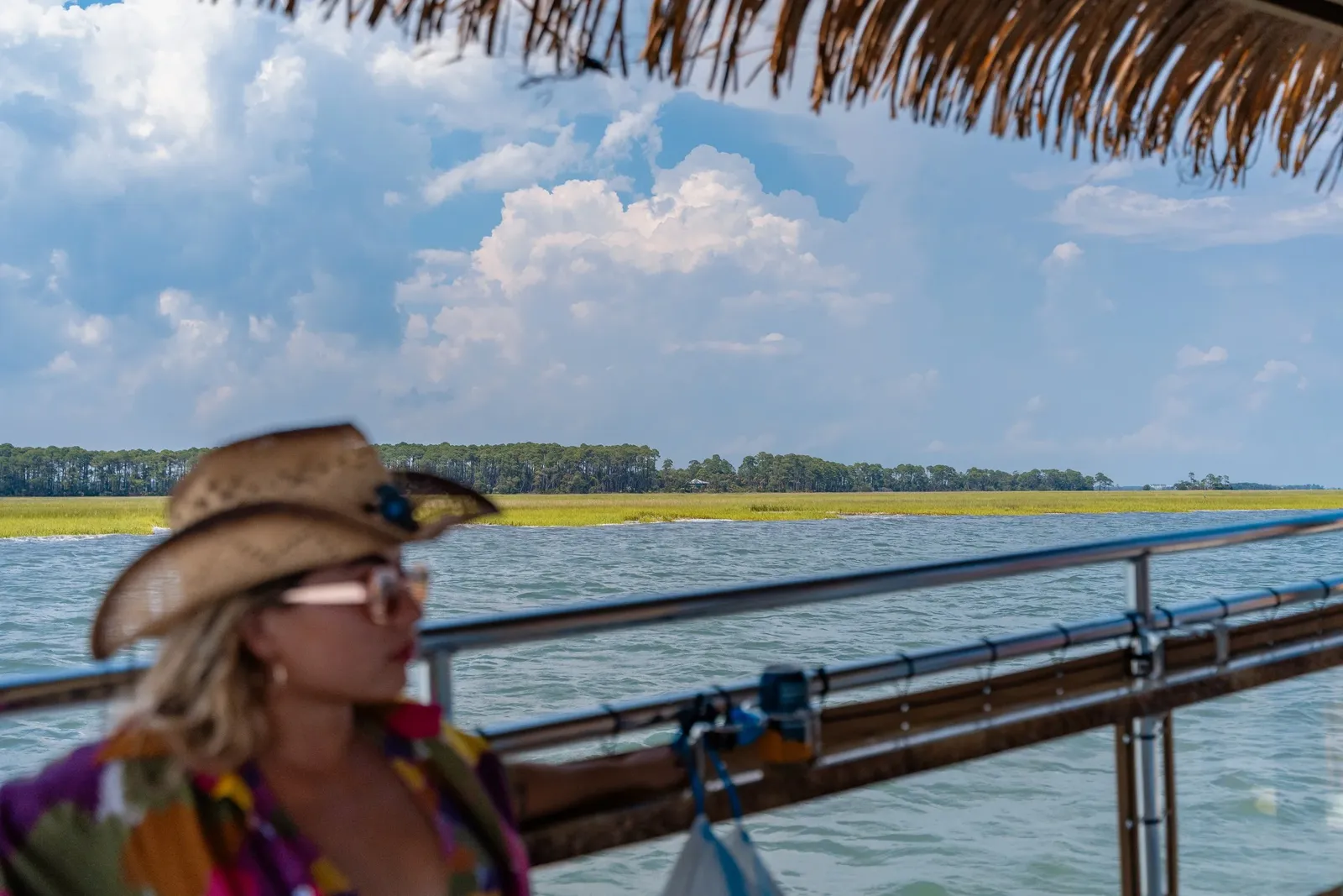 A guest in a sun hat looking out over the marsh and barrier islands